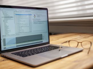 laptop on wooden desk with glasses