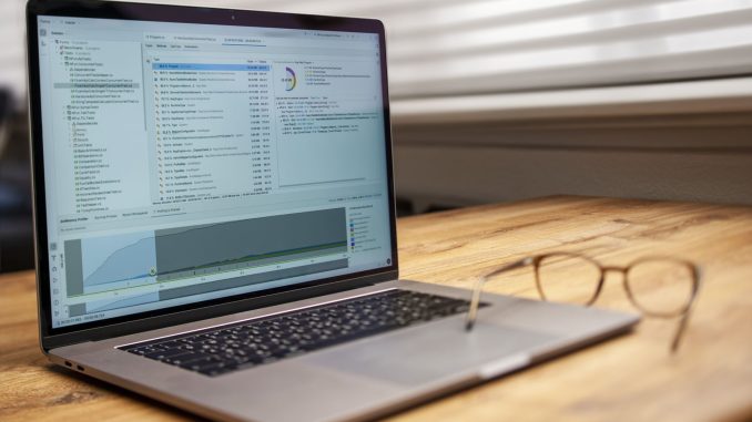 laptop on wooden desk with glasses