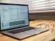 laptop on wooden desk with glasses